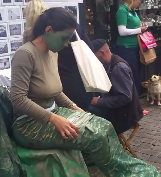 Girl dressed as a Merrew in Shop Street in Galway: according to tradition they can herald a forthcoming death like a Banshee (normally a river or lake dwelling variety), or lure men to their deaths like the Siren of European mythology, and there are tales of mortals marrying merrew as well!